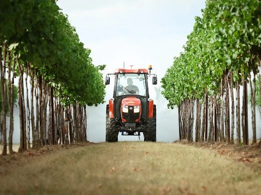 Tractor with the DUSTER G406 passing along a vineyard row